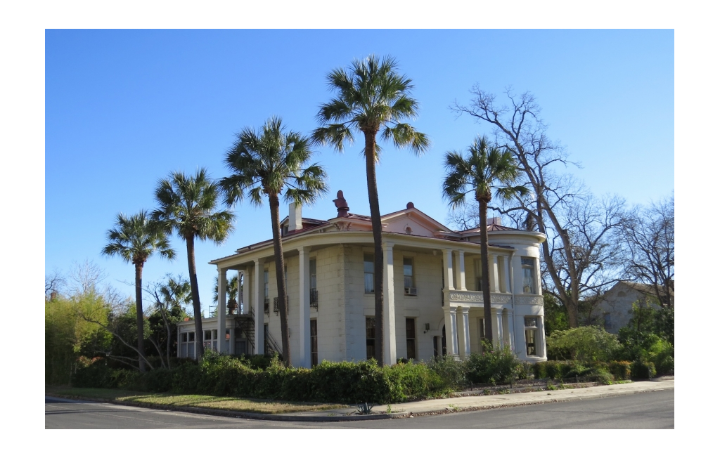 Large home with palm trees lining the landscaping.